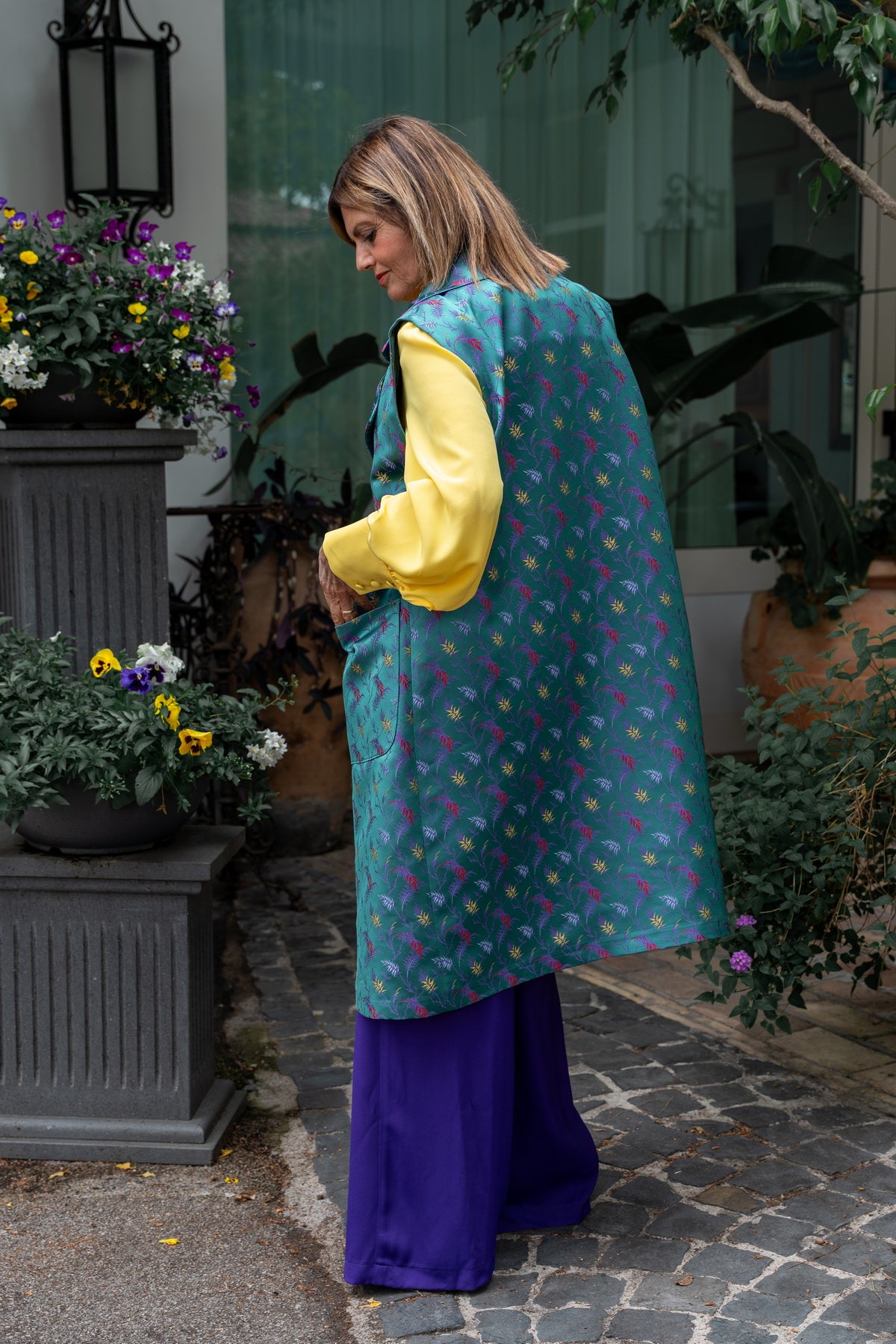 Gilet lungo donna seta elegante con design colorato in duchesse di seta, indossato in un ambiente estivo.