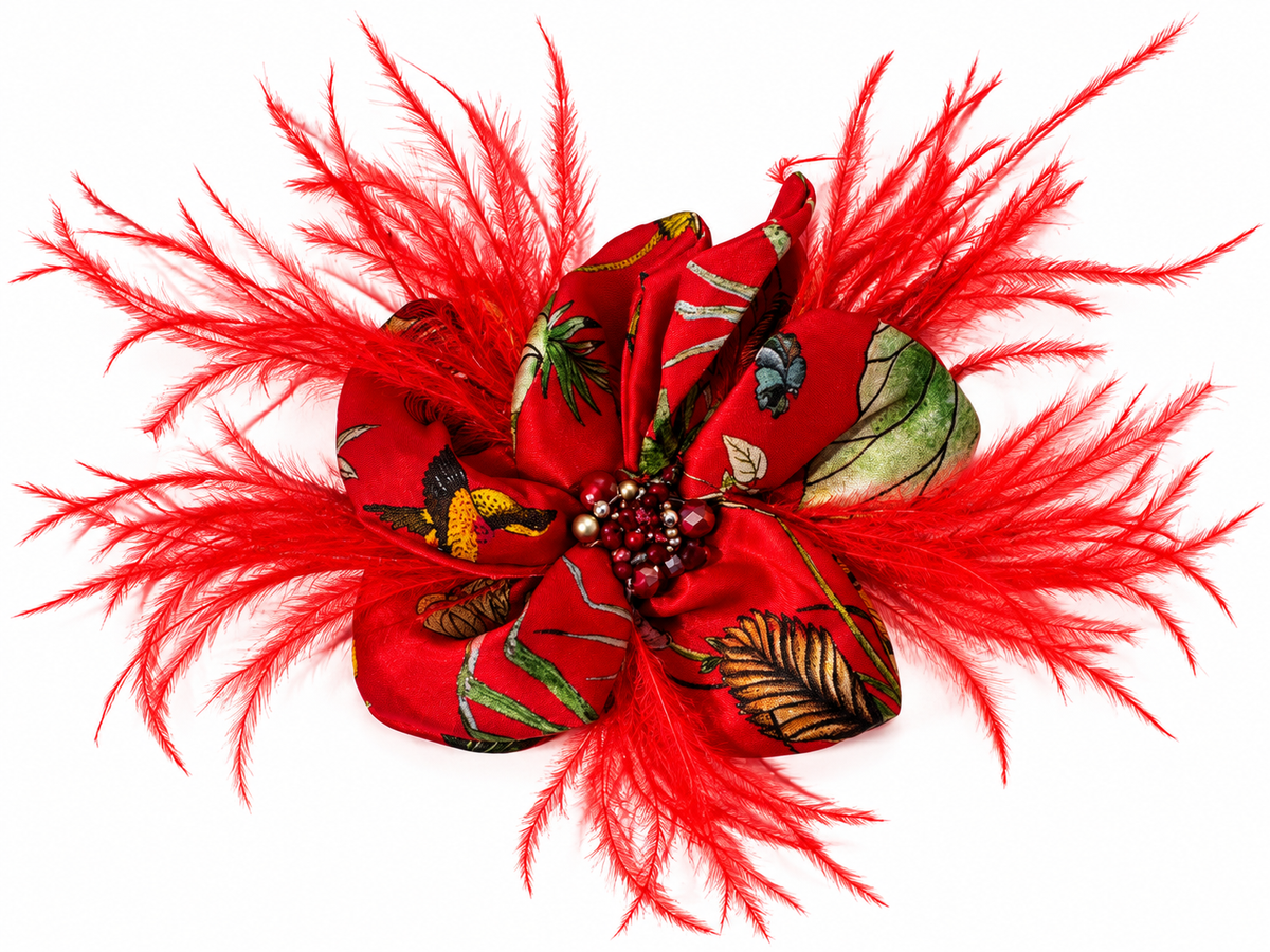 Spilla horti romana in seta con piume rosse e dettagli floreali, accessorio elegante e scenografico.