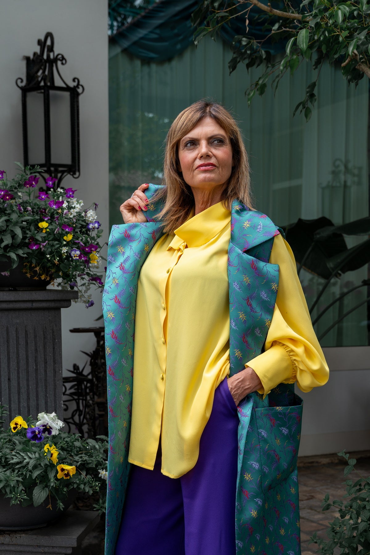 Gilet lungo donna seta elegante indossato con camicia gialla e pantaloni viola, look raffinato e moderno.