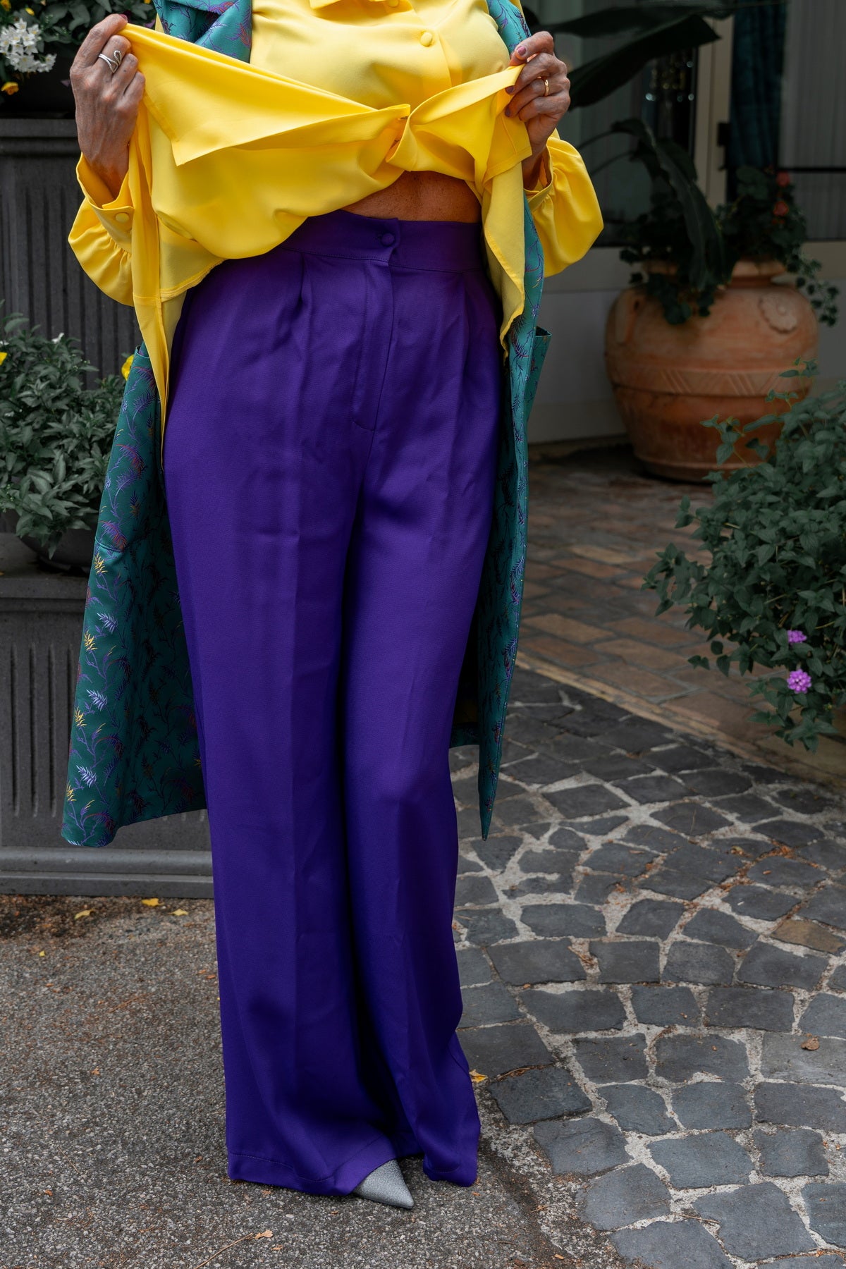 Pantaloni Marlene in viscosa viola abbinati a una blusa gialla, eleganti e comodi, ideali per look sofisticati.