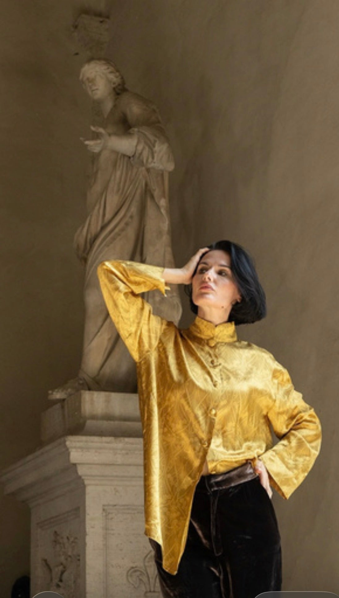 Camicia jacquard oro Domus Aurea indossata da una modella con sfondo di scultura, look elegante e artistico.