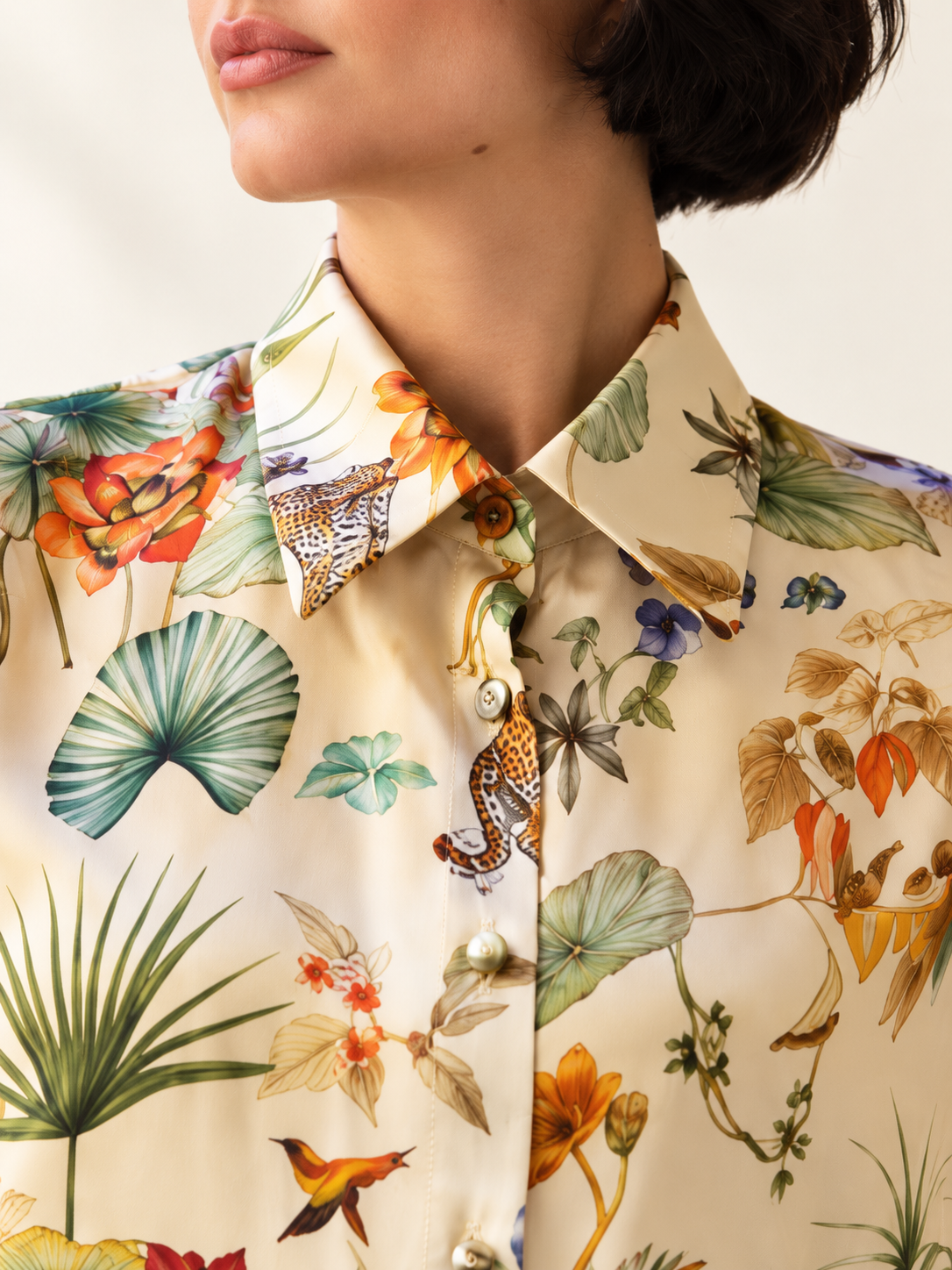 Camicia in seta avorio con stampa botanica con dettagli floreali e animali in tonalità vivaci.