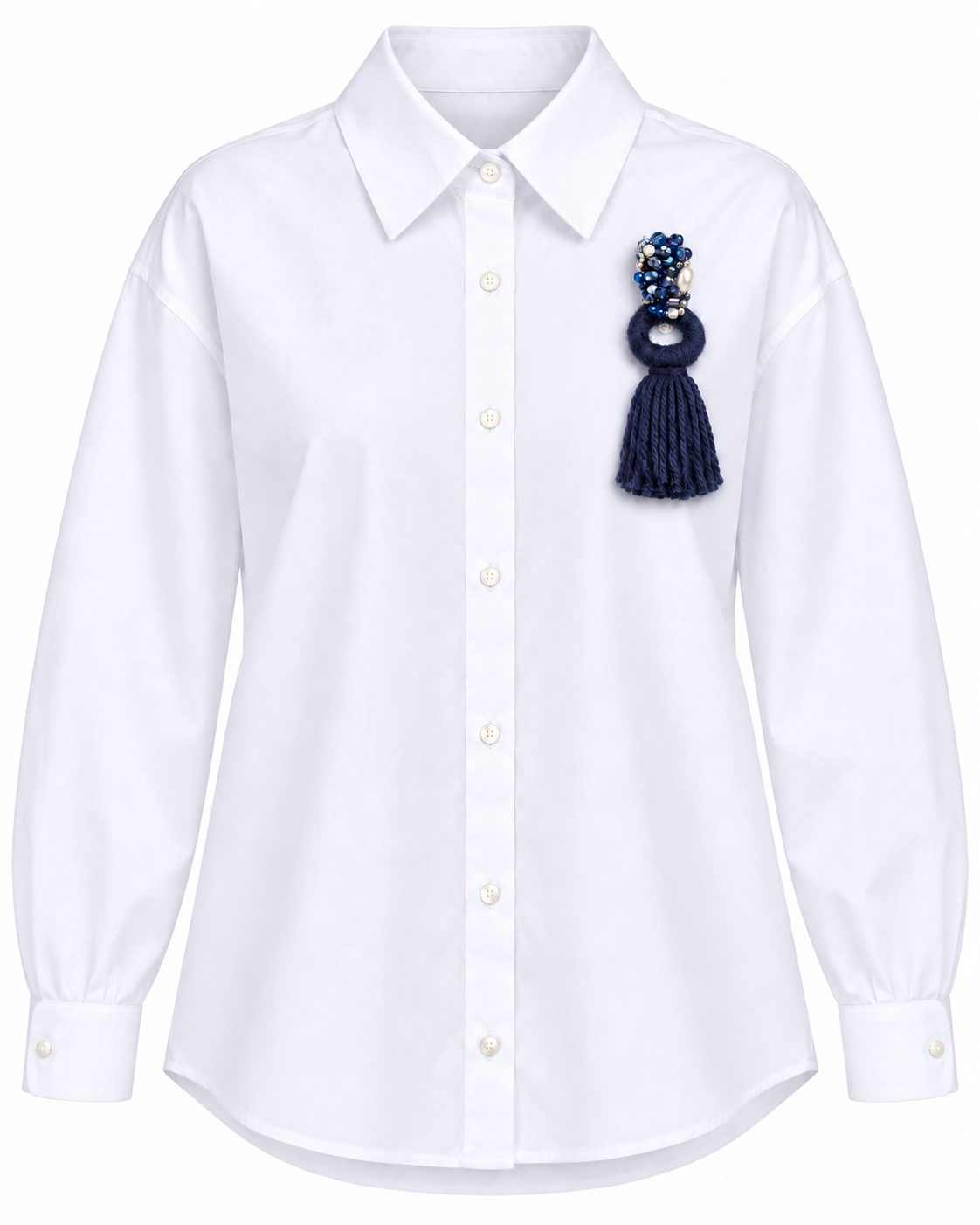 Camicia bianca con applicazione e nappina blu, maniche lunghe e colletto classico.