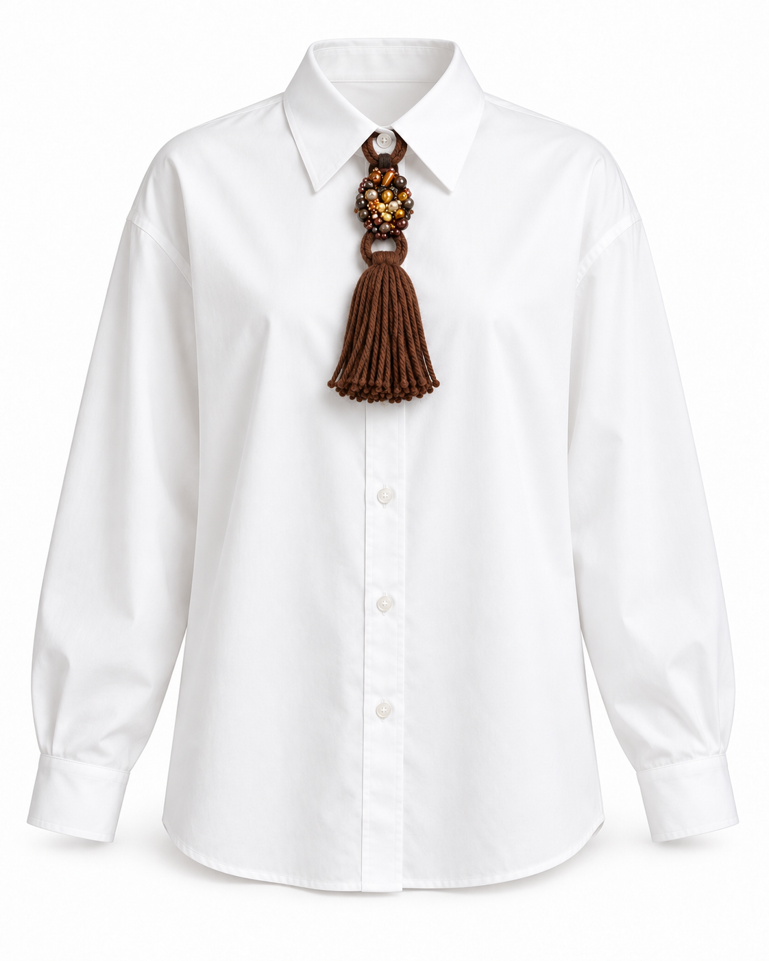 Spilla gioiello nappina lana marrone applicata su camicia bianca, accessorio elegante e originale.