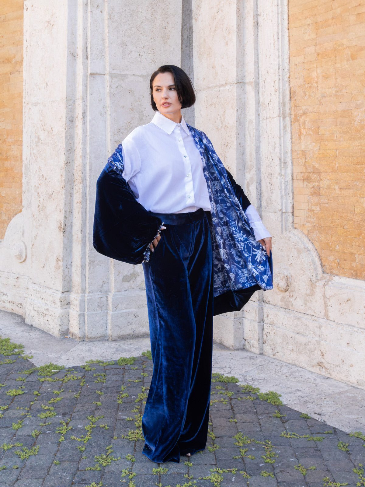 Pantalone Ottavia in velluto marrone palazzo indossato con camicia bianca e kimono blu, elegante look estivo.