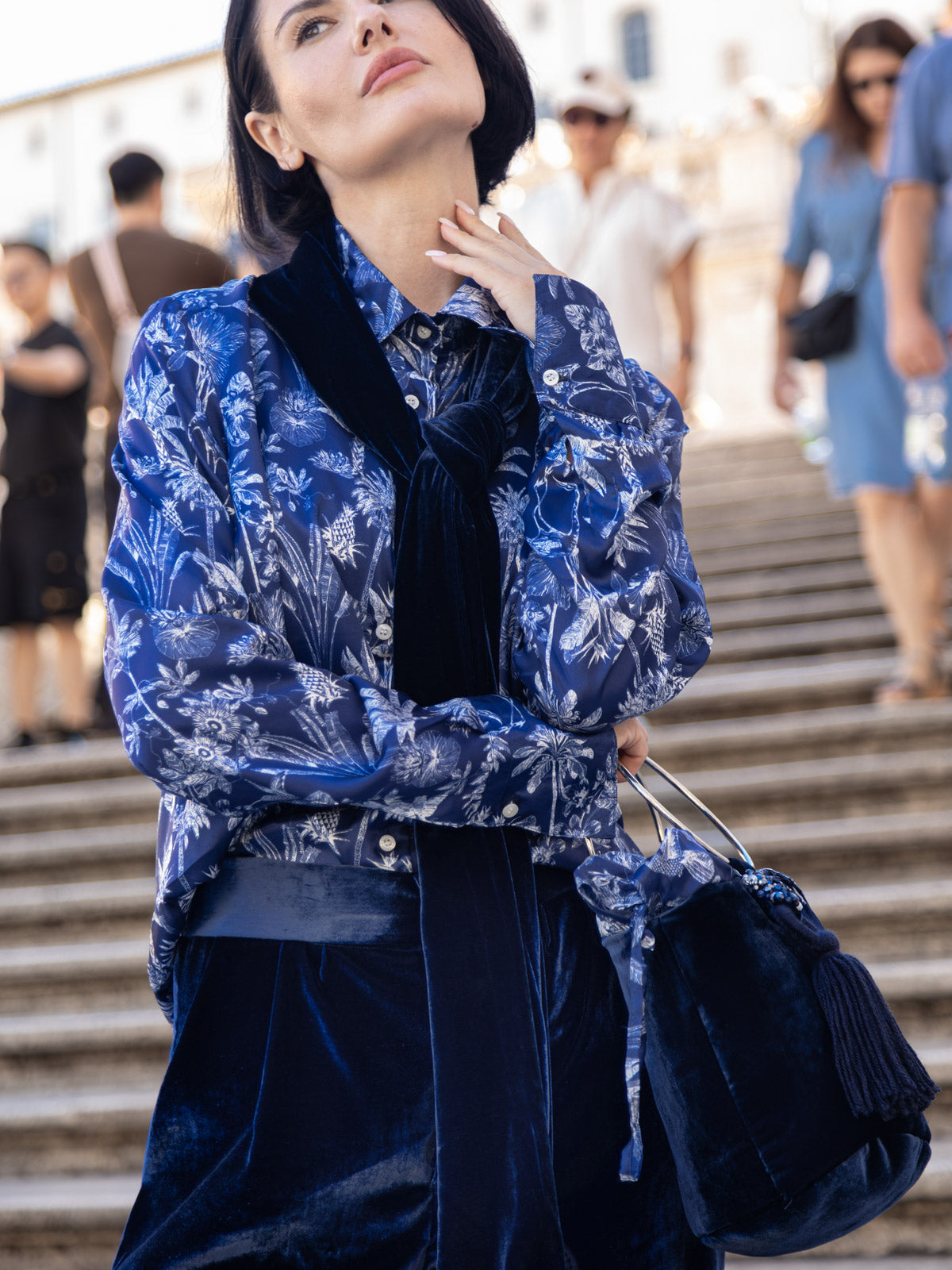 Modella che indossa una camicia viscosa Liberty con stampa floreale blu, fotografata in strada.