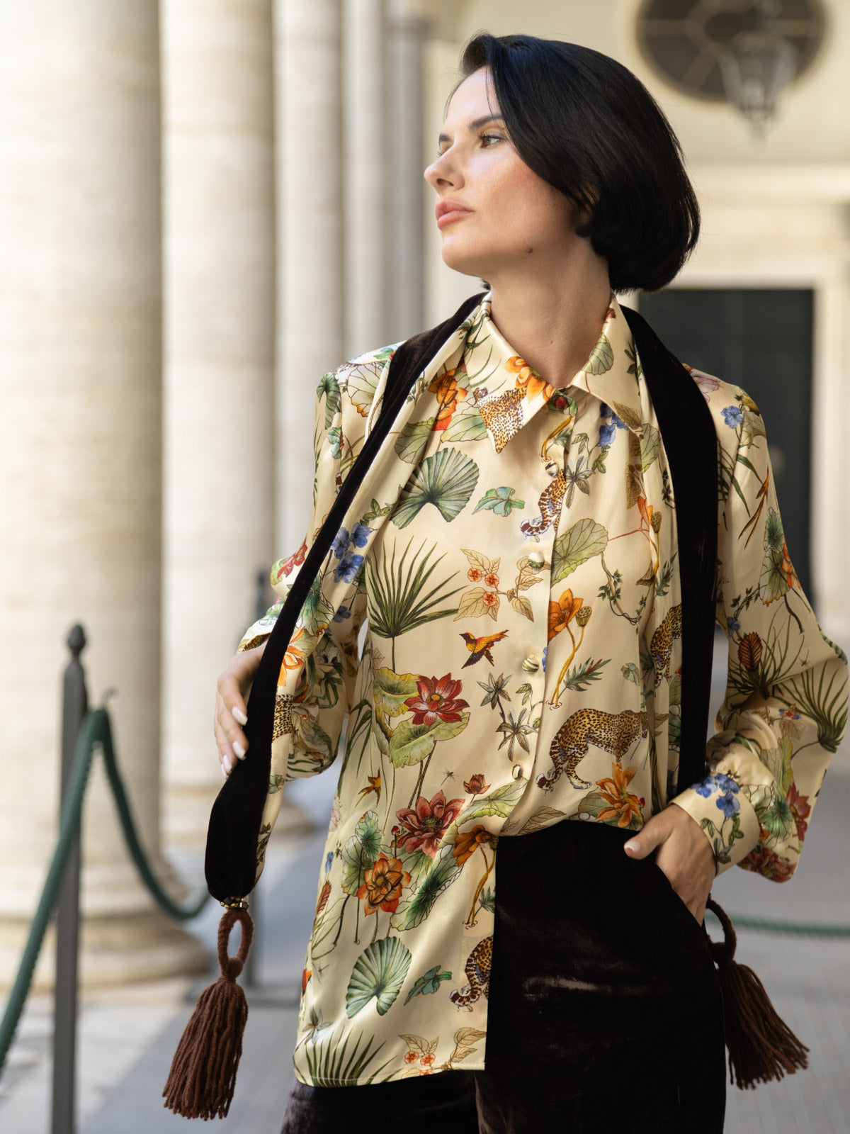 Camicia in seta avorio con stampa botanica indossata da una donna con dettagli floreali e felini.