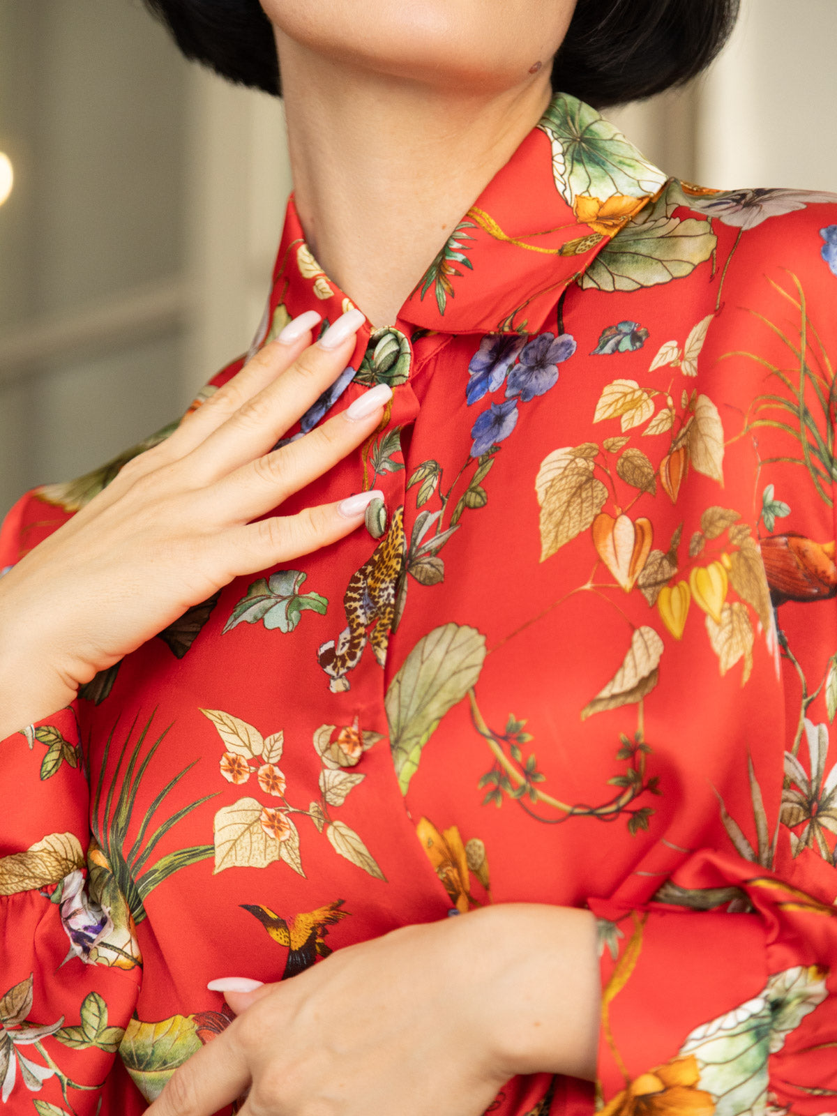Camicia in seta rossa Horti Imperiali con stampa floreale, colletto classico e taglio morbido, indossata da una donna.