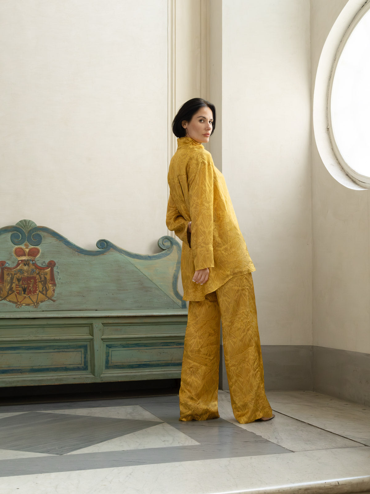 Pantalone Domus Aurea in viscosa oro champagne, modello palazzo, indossato con una camicia elegante.
