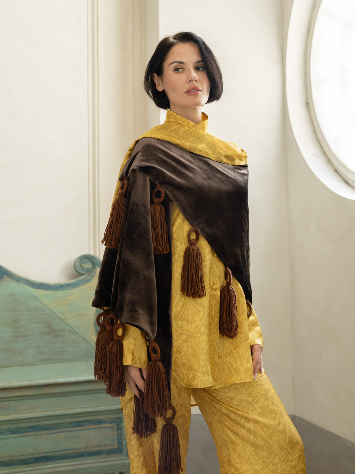 Pantalone Domus Aurea in viscosa oro champagne, abbinato a una camicia raffinata e scialle elegante con frange.