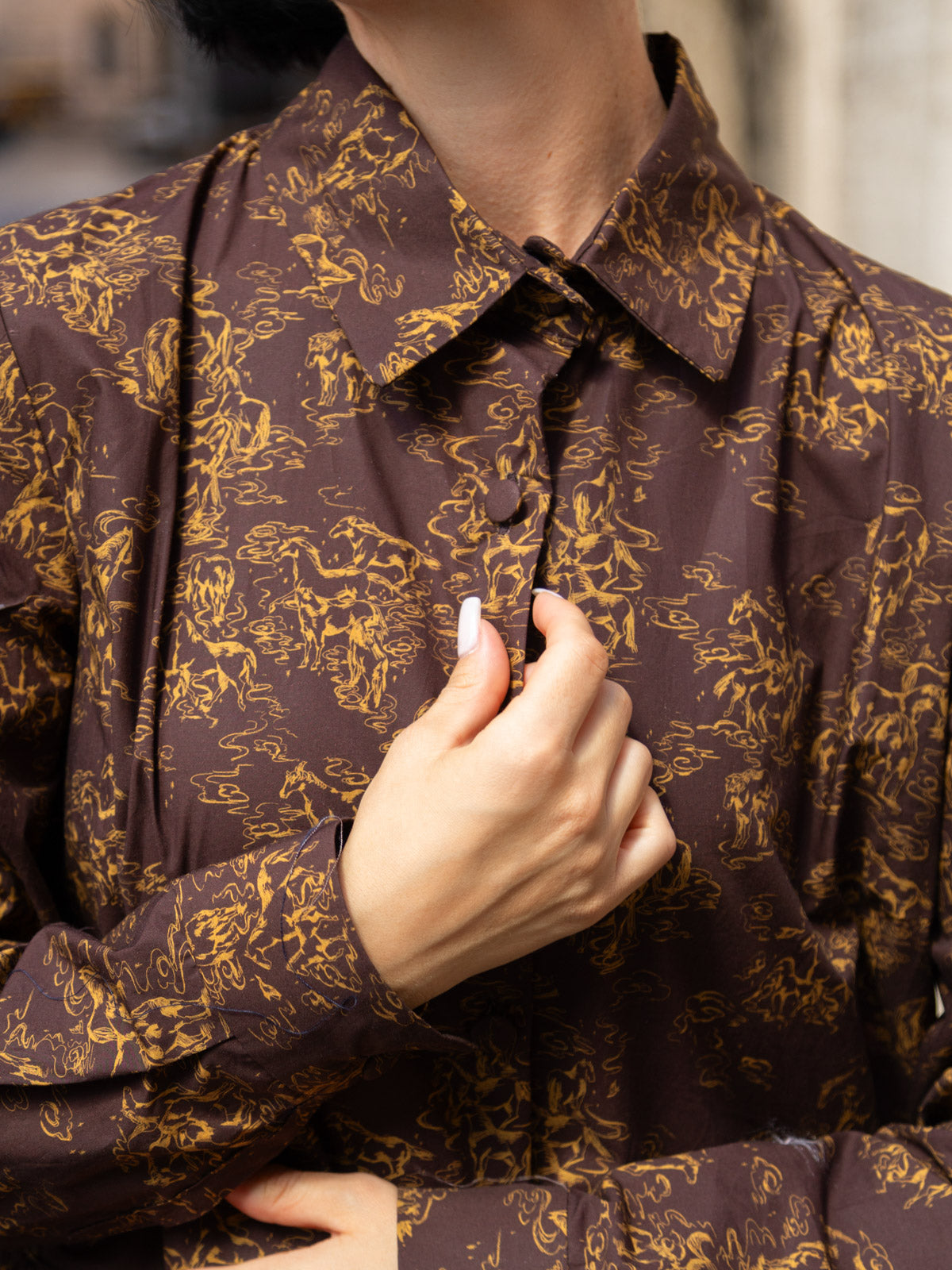 Dettaglio dell'abito lungo in tessuto Liberty con maniche eleganti e trama botanica distintiva.