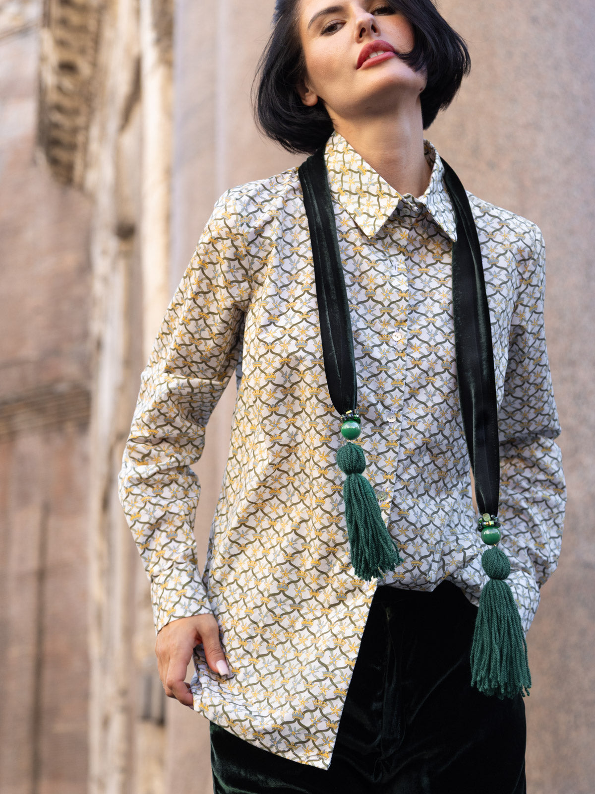 Sciarpa Eterna in velluto di seta nappine gioiello verde indossata da una donna elegante.